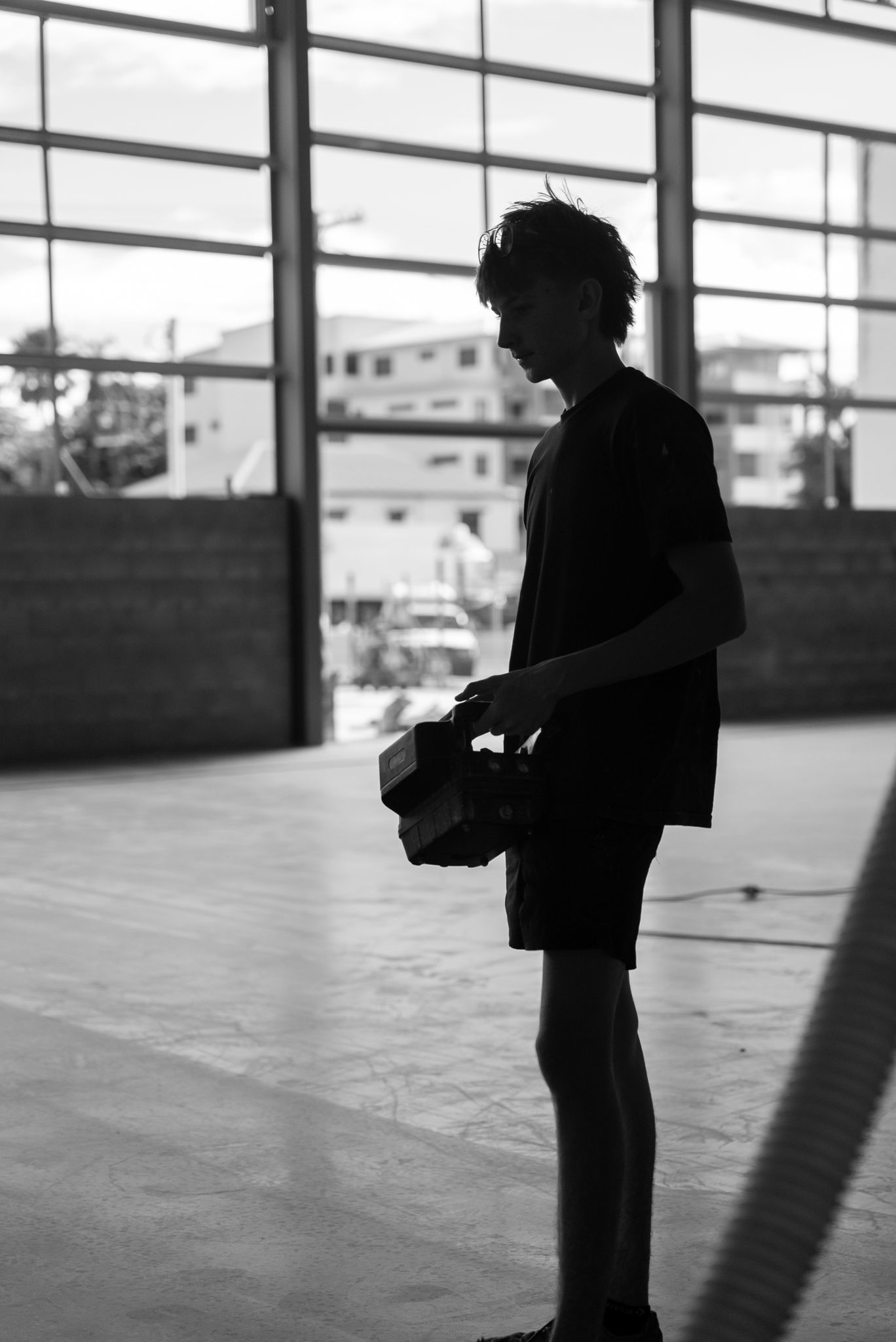 Silhouette of a Person Standing Indoors Near Large Windows — All Grind & Coat in Cairns, QLD