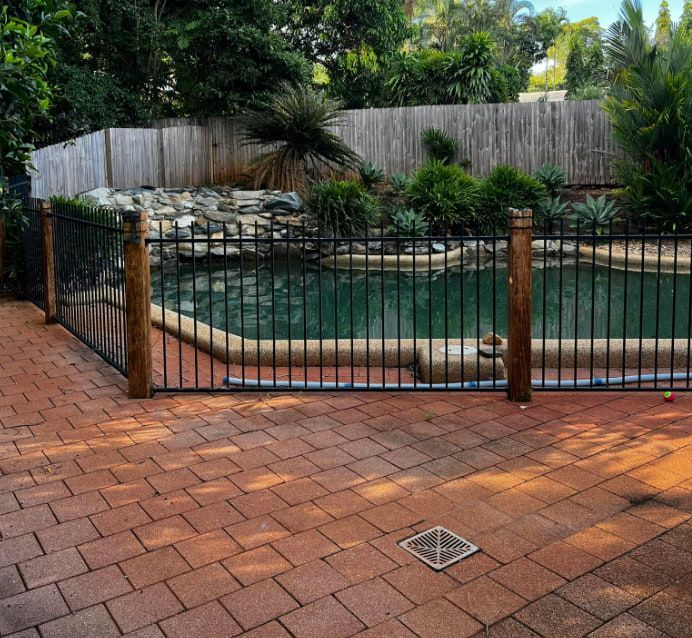 A Wrought Iron Fence Surrounds a Large Swimming Pool — All Grind & Coat in Cairns, QLD