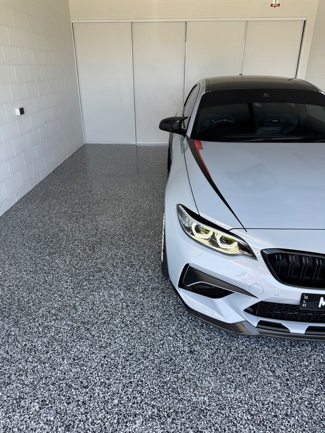 White BMW Car Parked in a Garage With Speckled Grey Flooring and White Walls — All Grind & Coat in Cairns, QLD