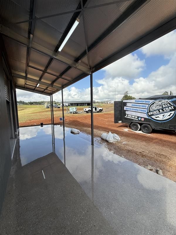 Covered Patio With Reflective Concrete Floor Beside a Dirt — All Grind & Coat in Atherton, QLD