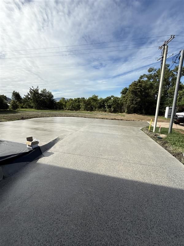 Empty Paved Lot Beside Trees and Utility Poles Under a Bright, Partly Cloudy Sky — All Grind & Coat in Tablelands, QLD