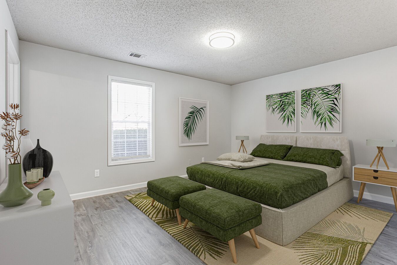 Bright bedroom with a green bed, white walls, and framed plant art near a window.