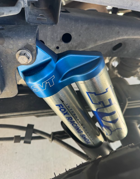 Blue and silver aftermarket reservoir mounted under a vehicle chassis