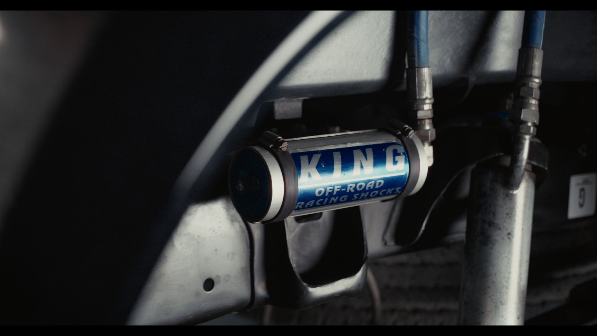 Blue KING shock absorber mounted under a vehicle, with surrounding suspension parts visible.