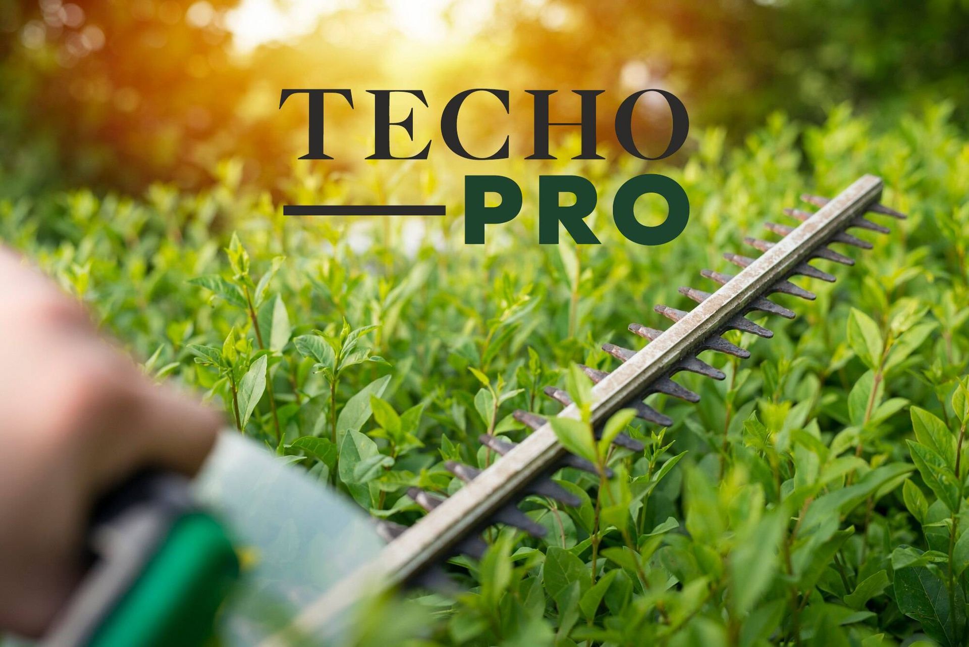 Lawn mower cutting lush green grass with TECHO PRO logo overlaid