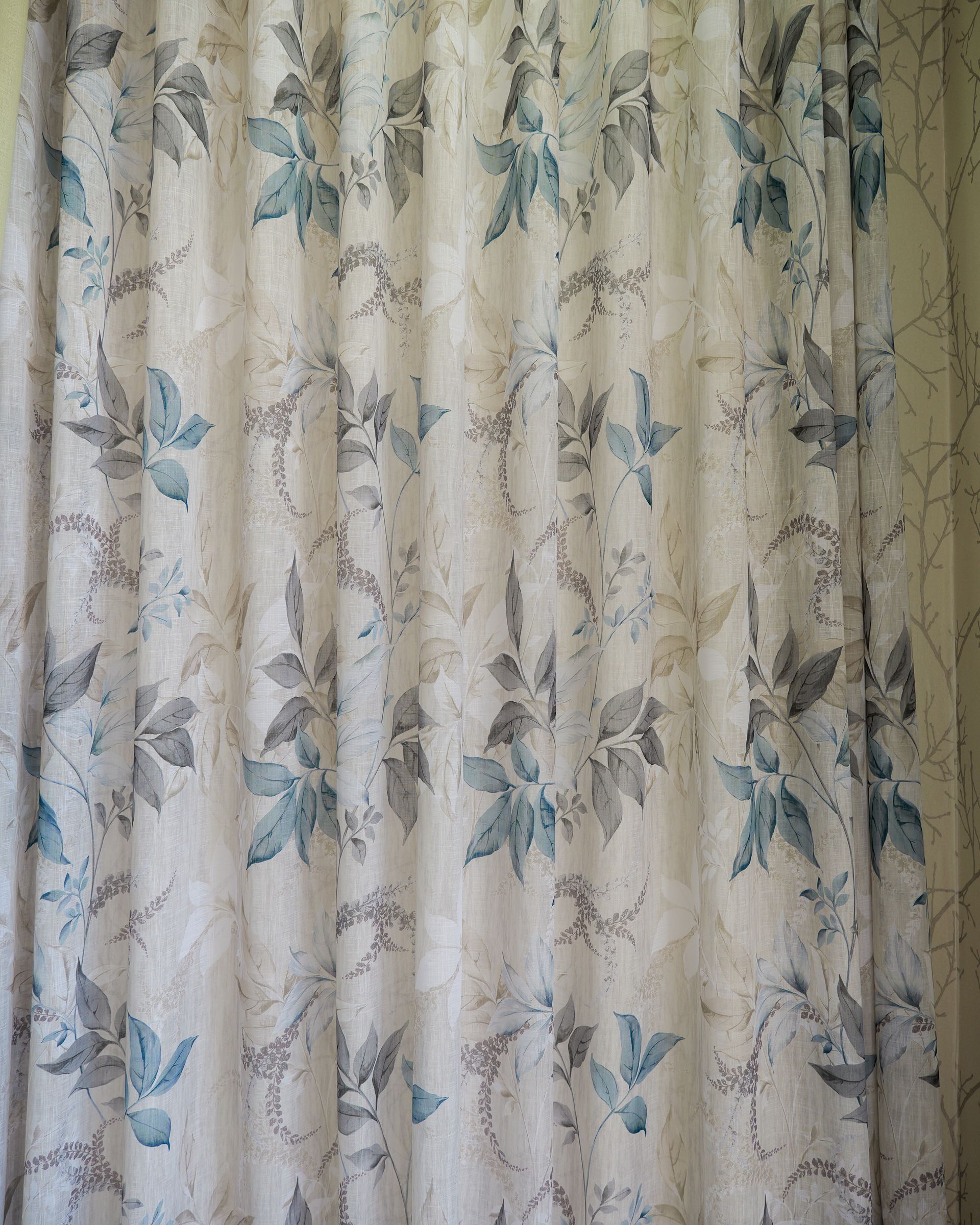 Tende beige chiaro con motivo floreale e a uccellini blu, chiuse