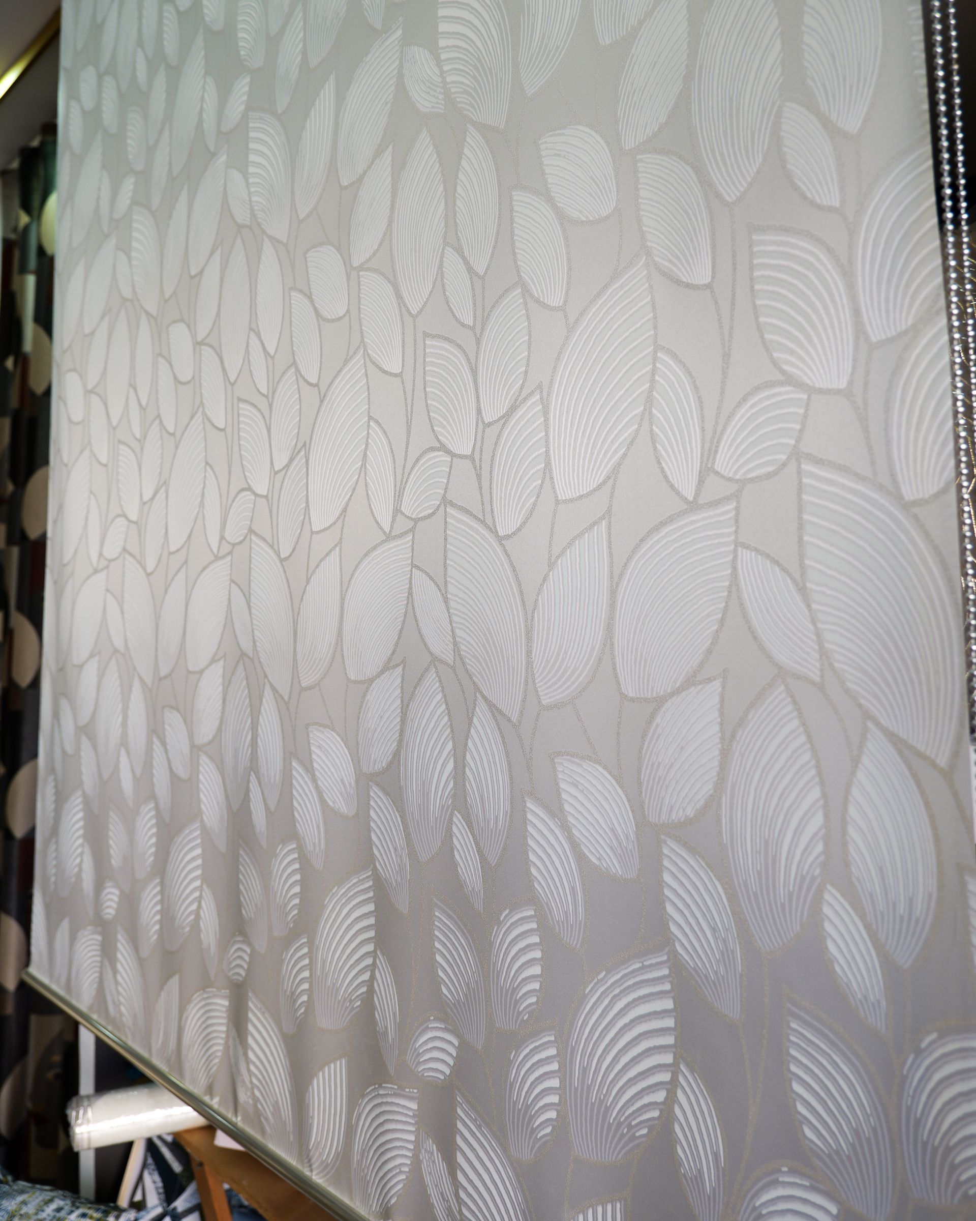Rivestimento murale grigio chiaro con una texture e un motivo a foglie