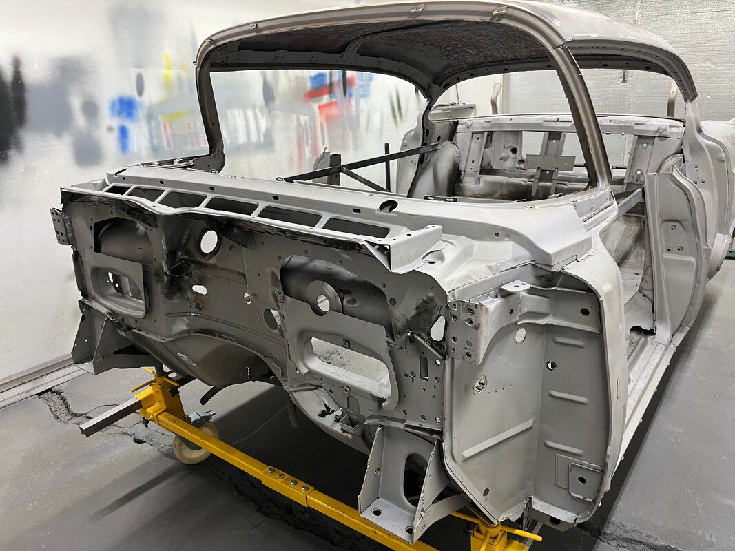 A car is being built in a factory on a conveyor belt.