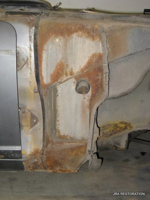 A rusty piece of metal is sitting on the ground.