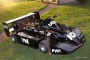A black lawn mower is sitting on top of a lush green lawn.