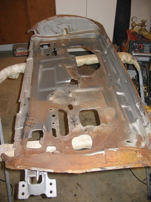 A rusty piece of metal is sitting on a table in a garage.