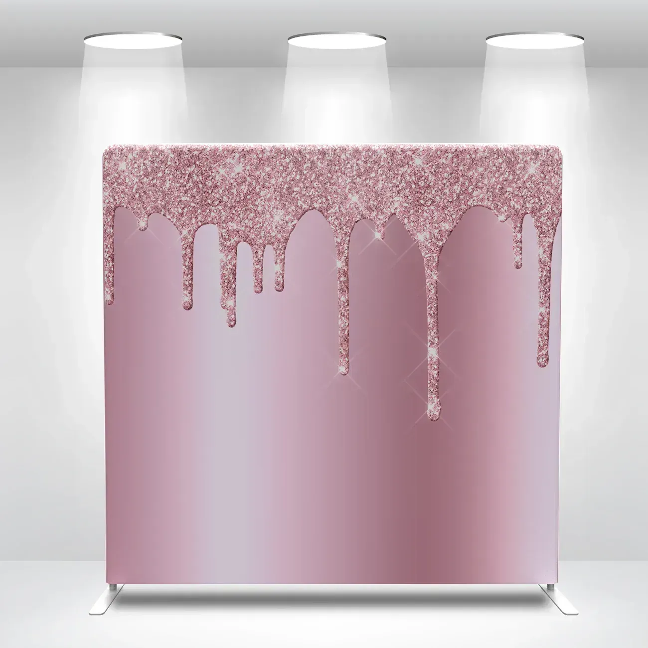 Pink glittering cake with dripping icing under three spotlights on a white background