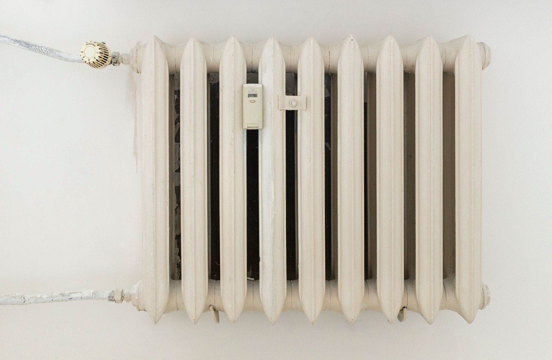 Person inspecting a radiator under a window in a bright room