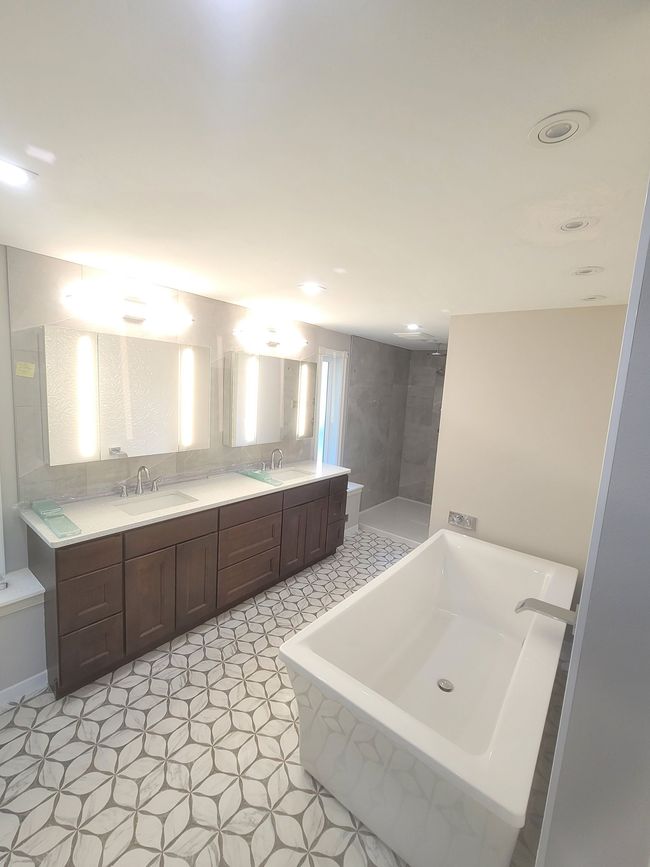 A bathroom with a bathtub , sink , and mirror.