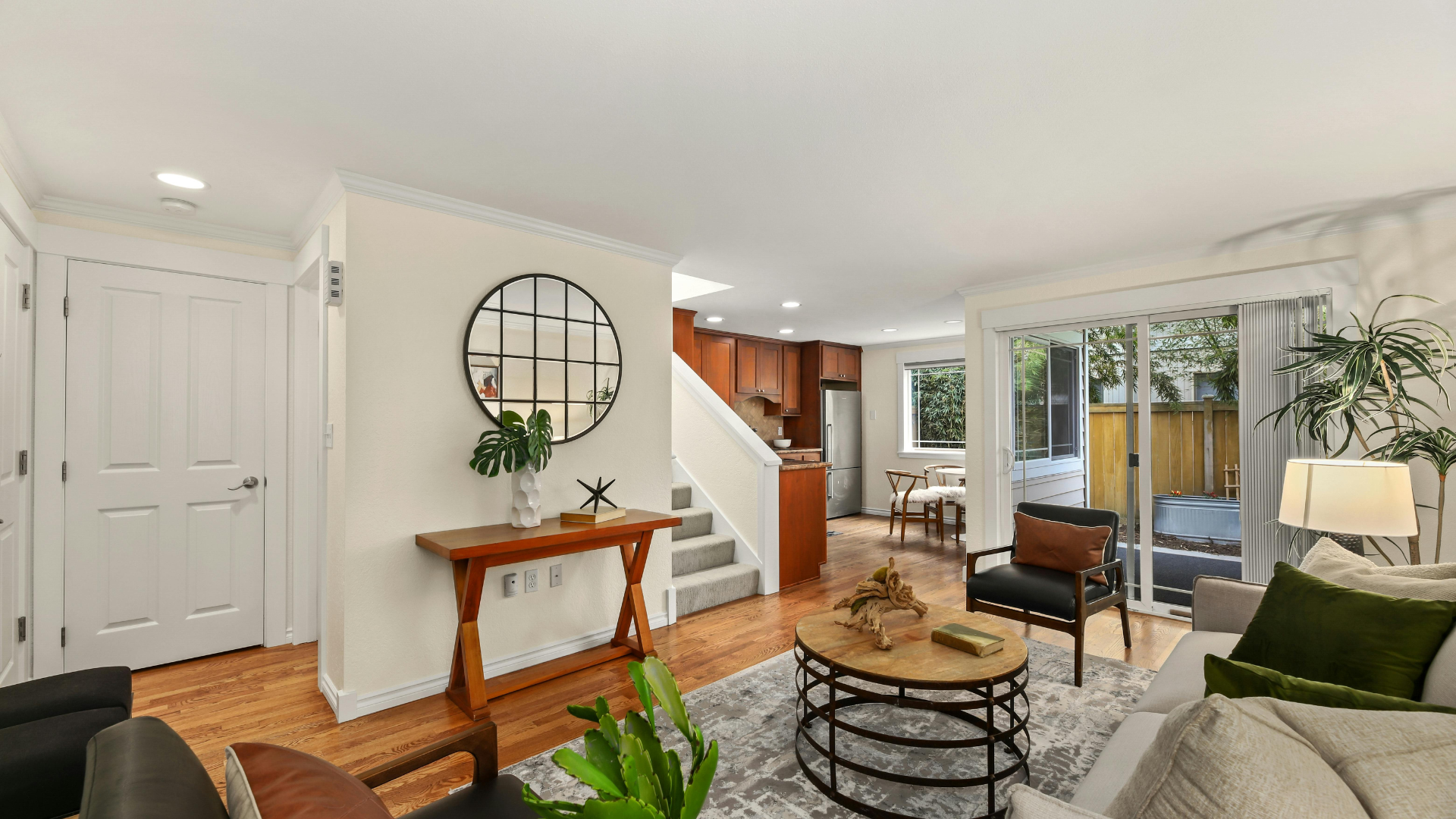 Modern luxury living room with gray sofas, wood-paneled walls, circular ceiling lights, and a wall-mounted TV