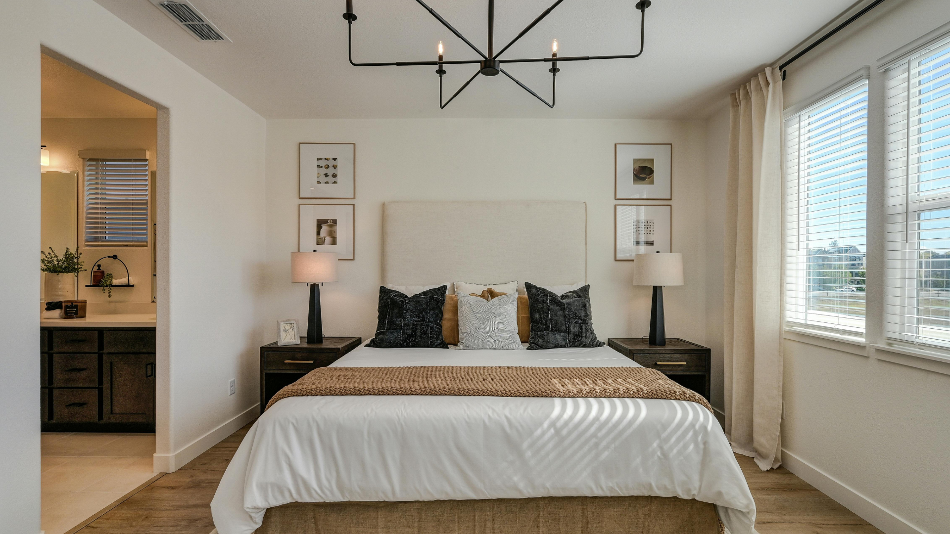 Elegant modern bedroom with gray bed, sofa, marble accents, and gold lighting details