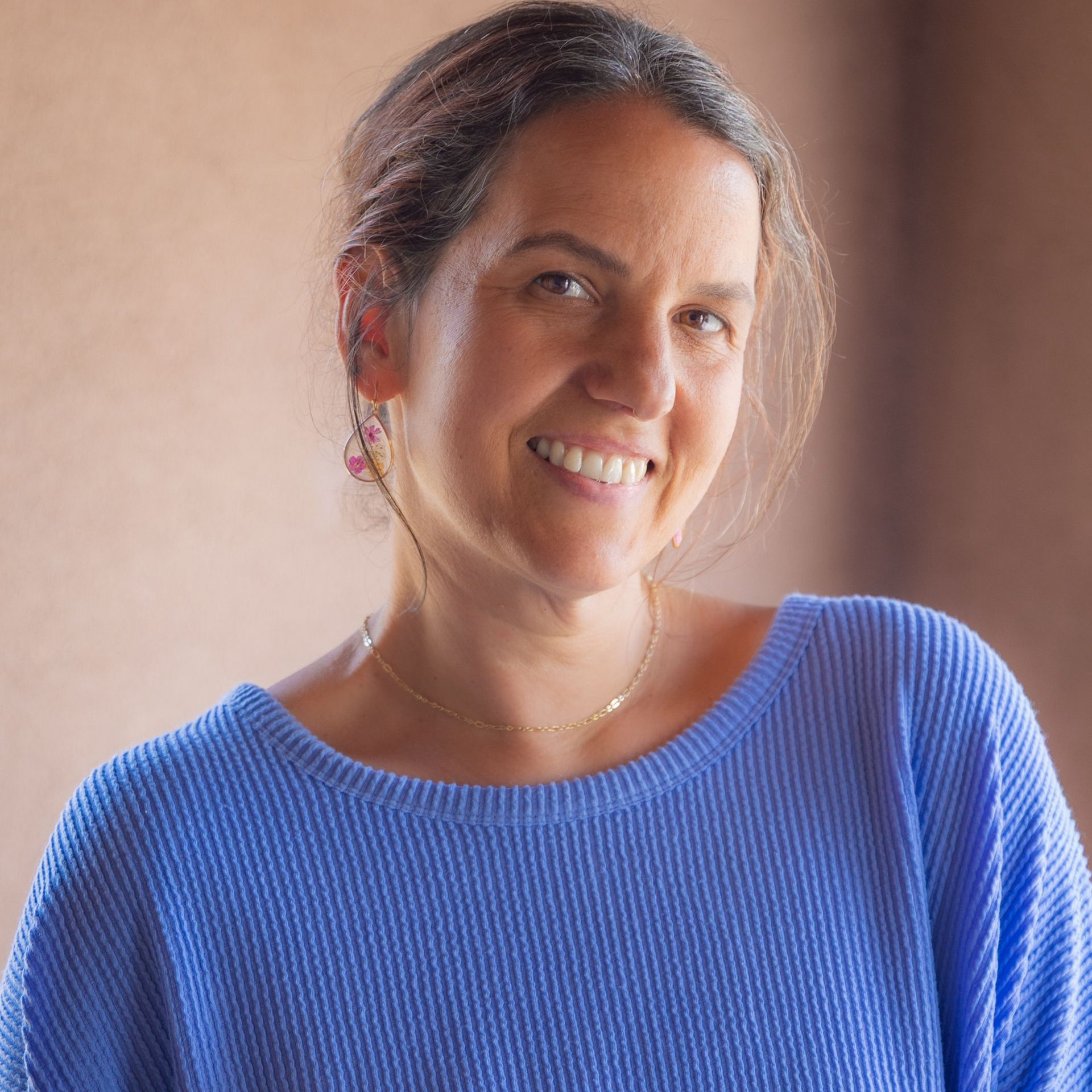Jena Kohashi, LMPC, is a Deaf licensed master's professional counselor. She is smiling at the camera and wearing a light blue sweater.