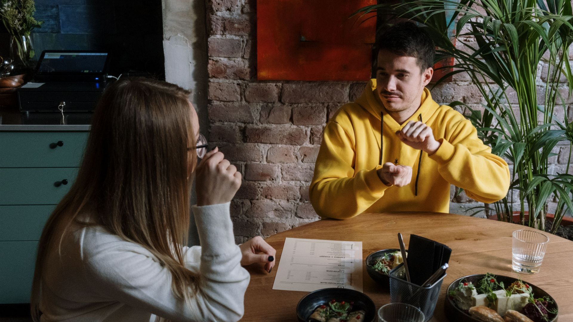 Two people signing in American Sign Language during a face-to-face conversation