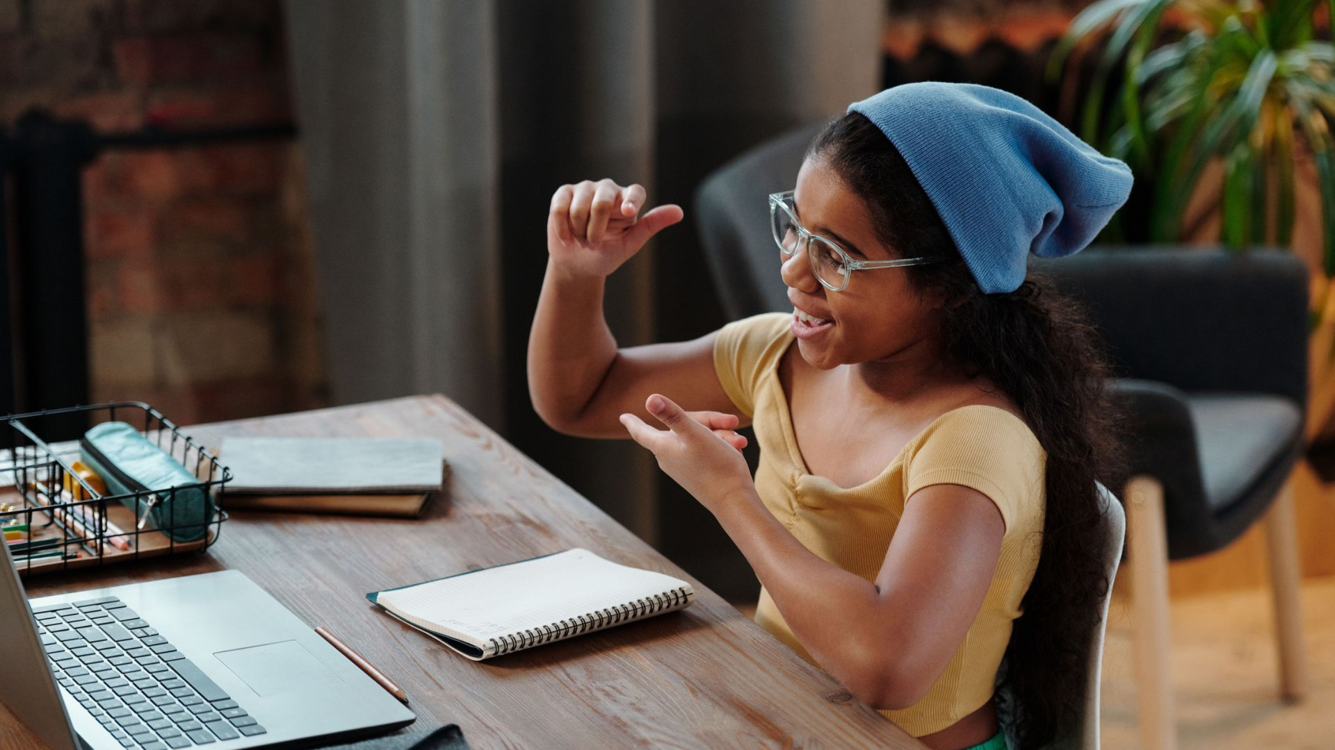 Young person smiling and signing in American Sign Language during a lively conversation