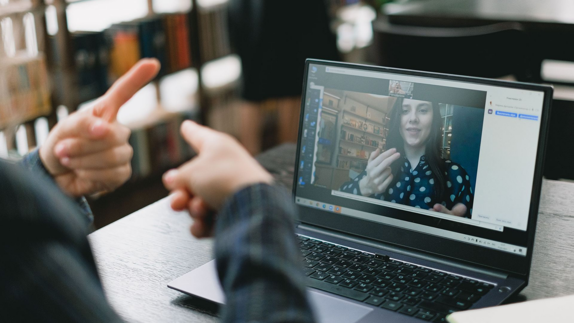 Person using ASL on a laptop video call with a Deaf therapist during an online telehealth session