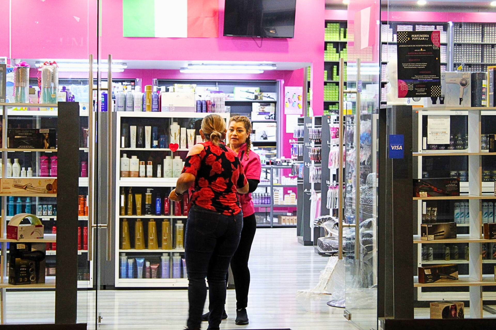 Dos mujeres están paradas en una tienda hablando entre sí.