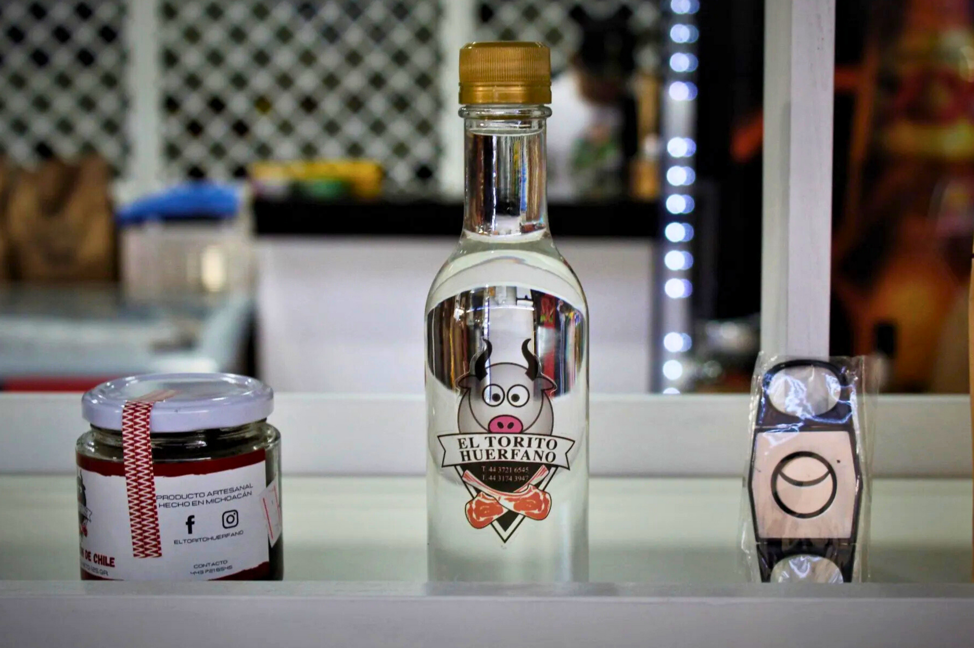 Una botella de vodka está en un estante junto a un frasco de mermelada.