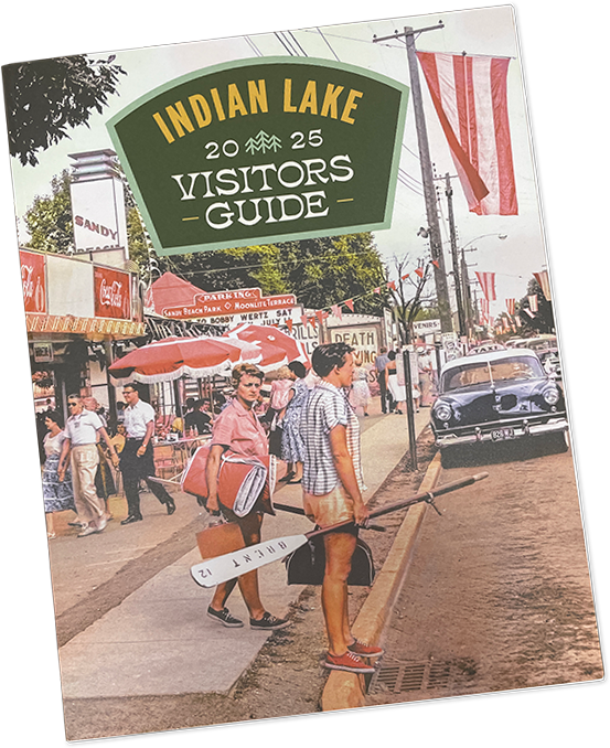 Indian Lake 2026 Visitors Guide cover featuring a vintage-style street scene with people and a car.