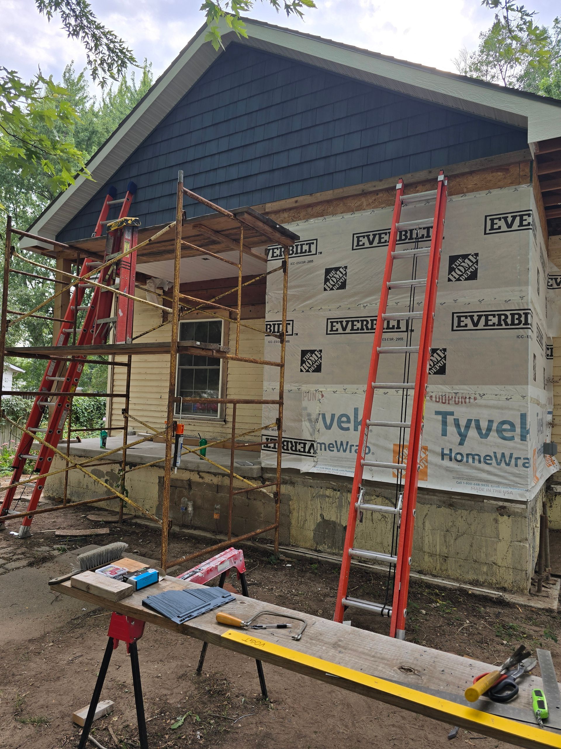 Installing new vinyl siding on a gable end of a house.
