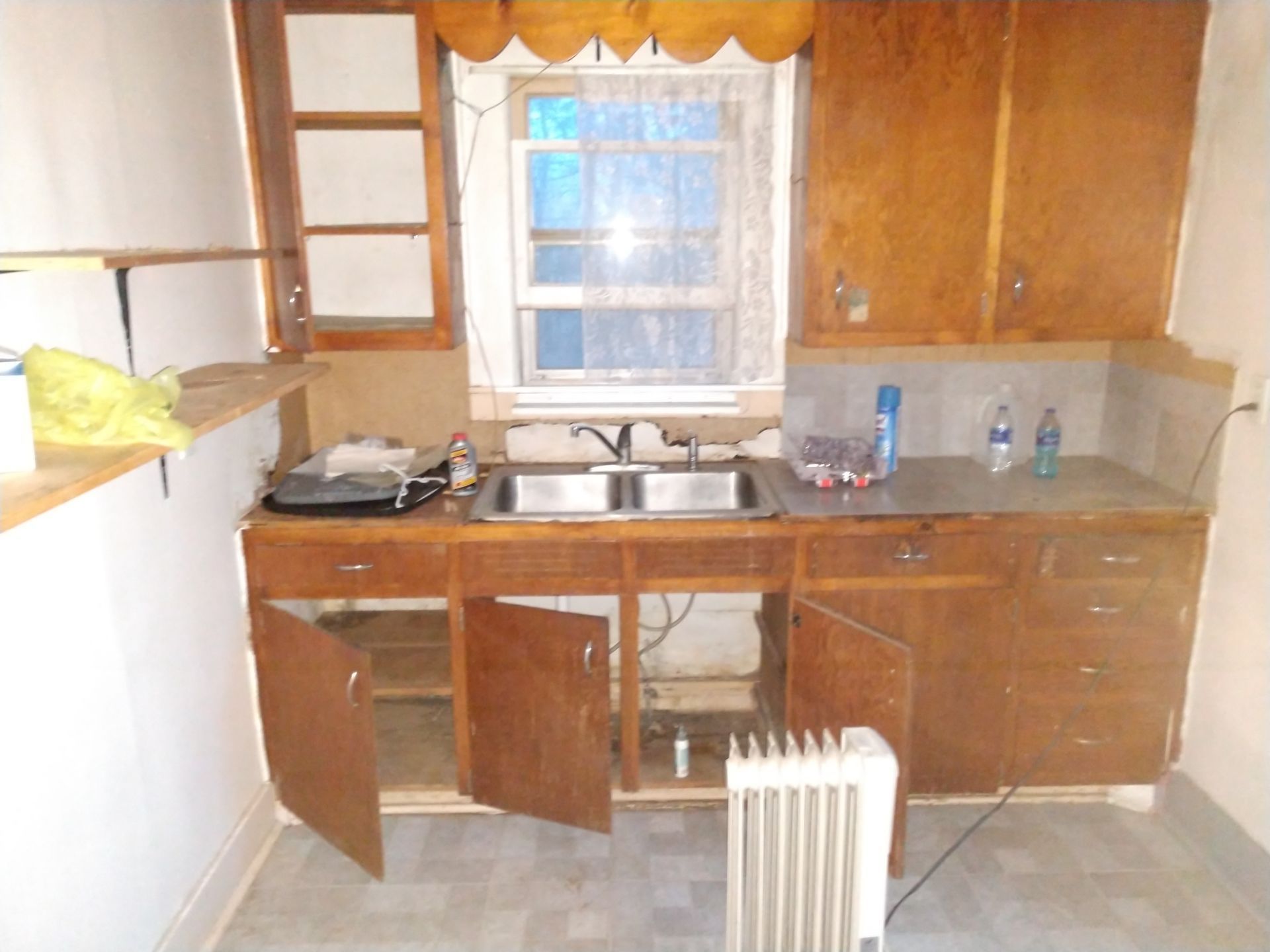 Old Kitchen with wood cabinets and failing backsplash that needs to be remodeled