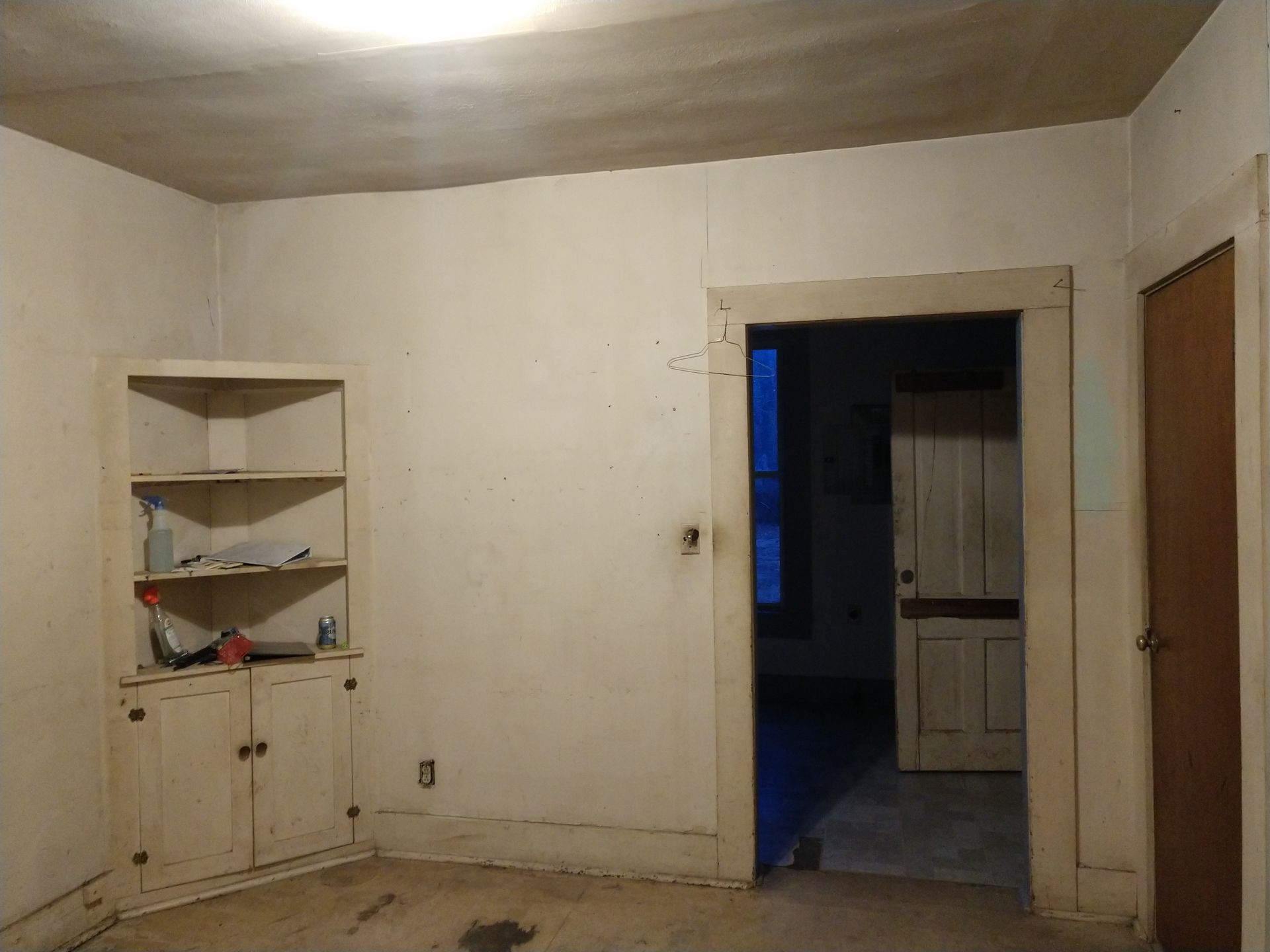 Small Dining Room with corner shelf, dingy white walls and yellowed trim in need of remodel