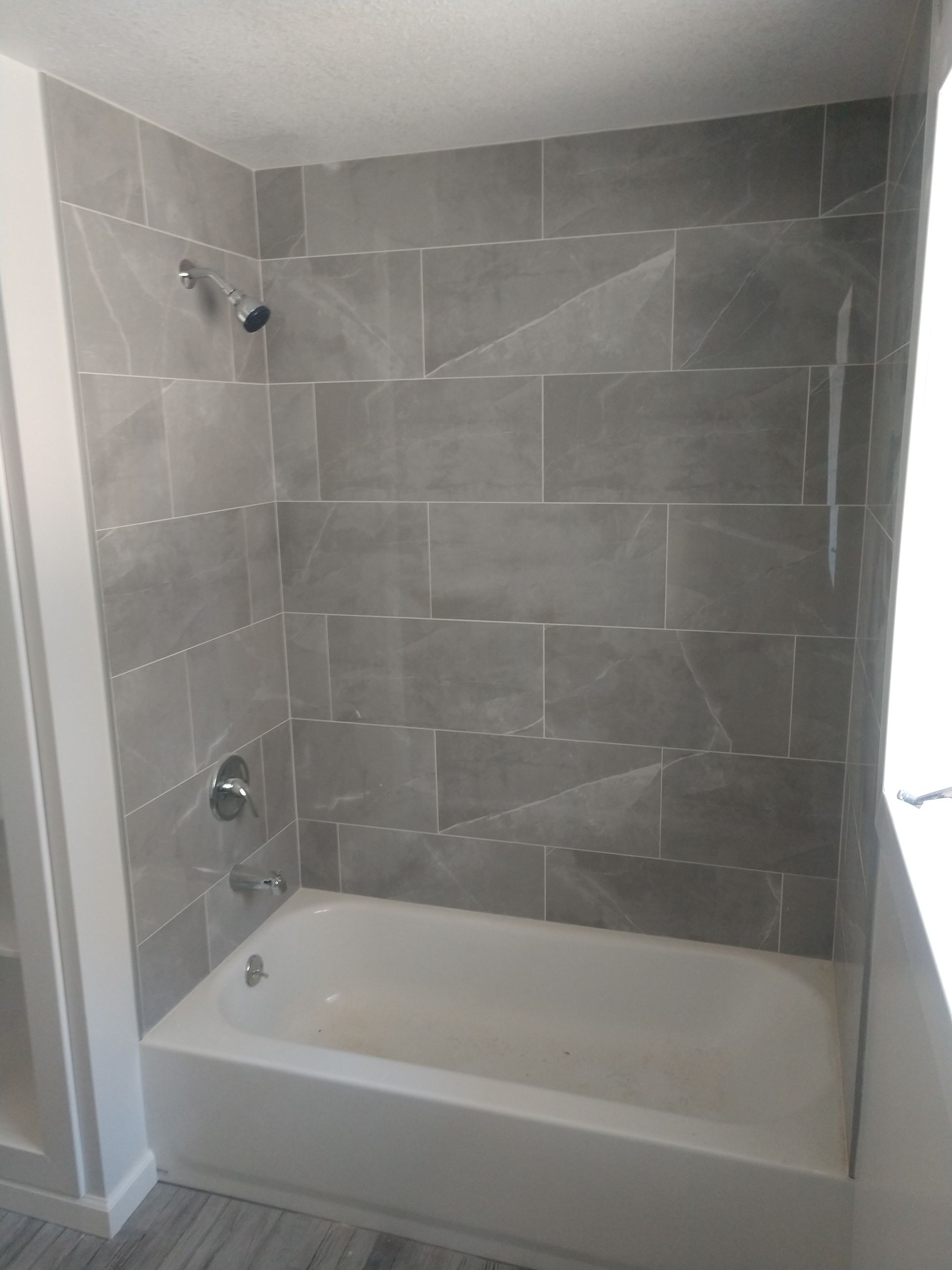 New Shower and Tub Installation with Grey Tile Backsplash