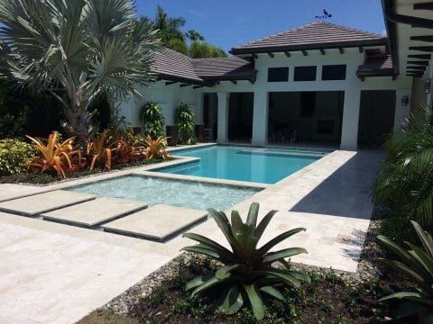 A house with a large swimming pool in front of it