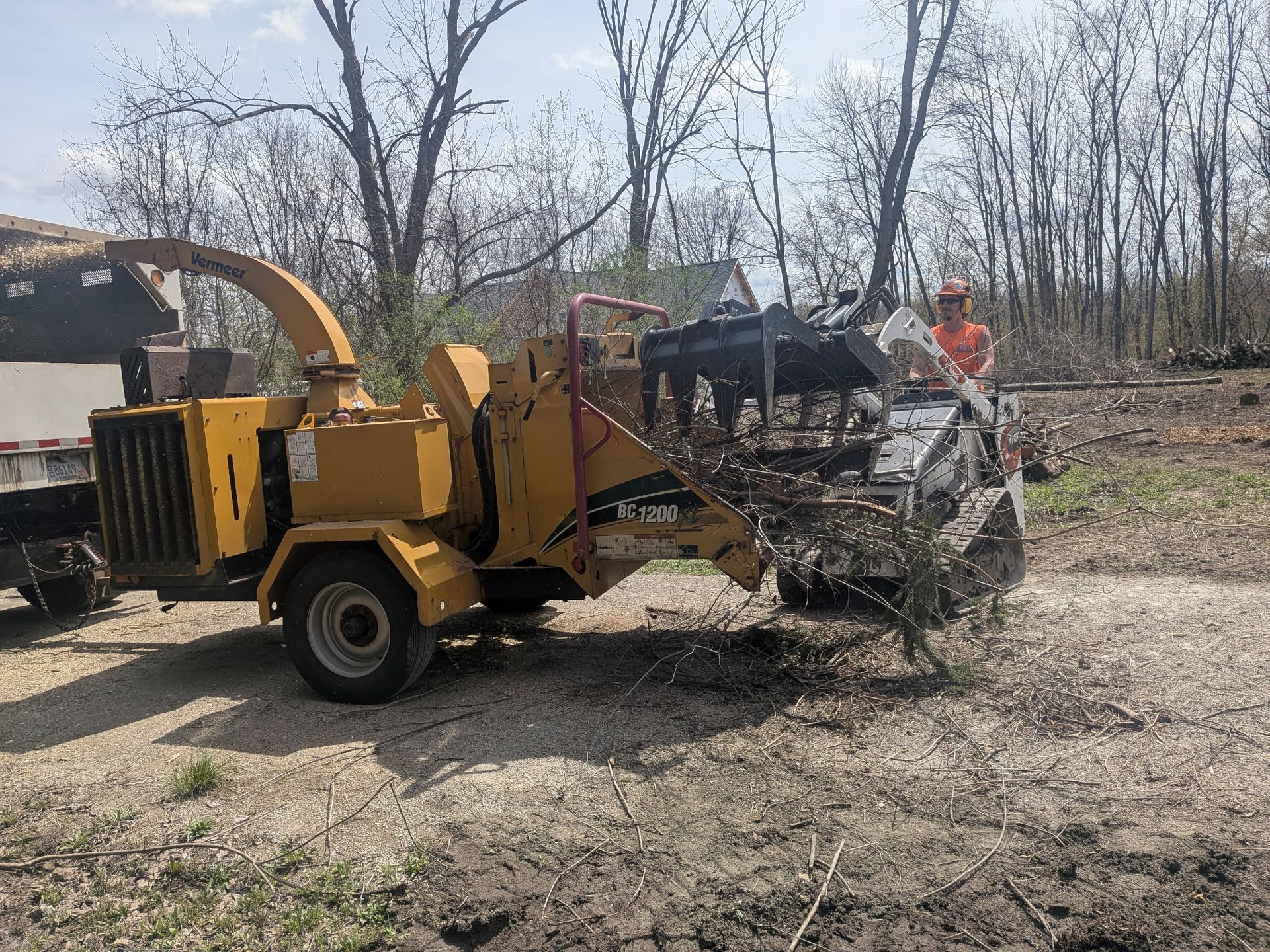 A tree is being cut down in front of a house.