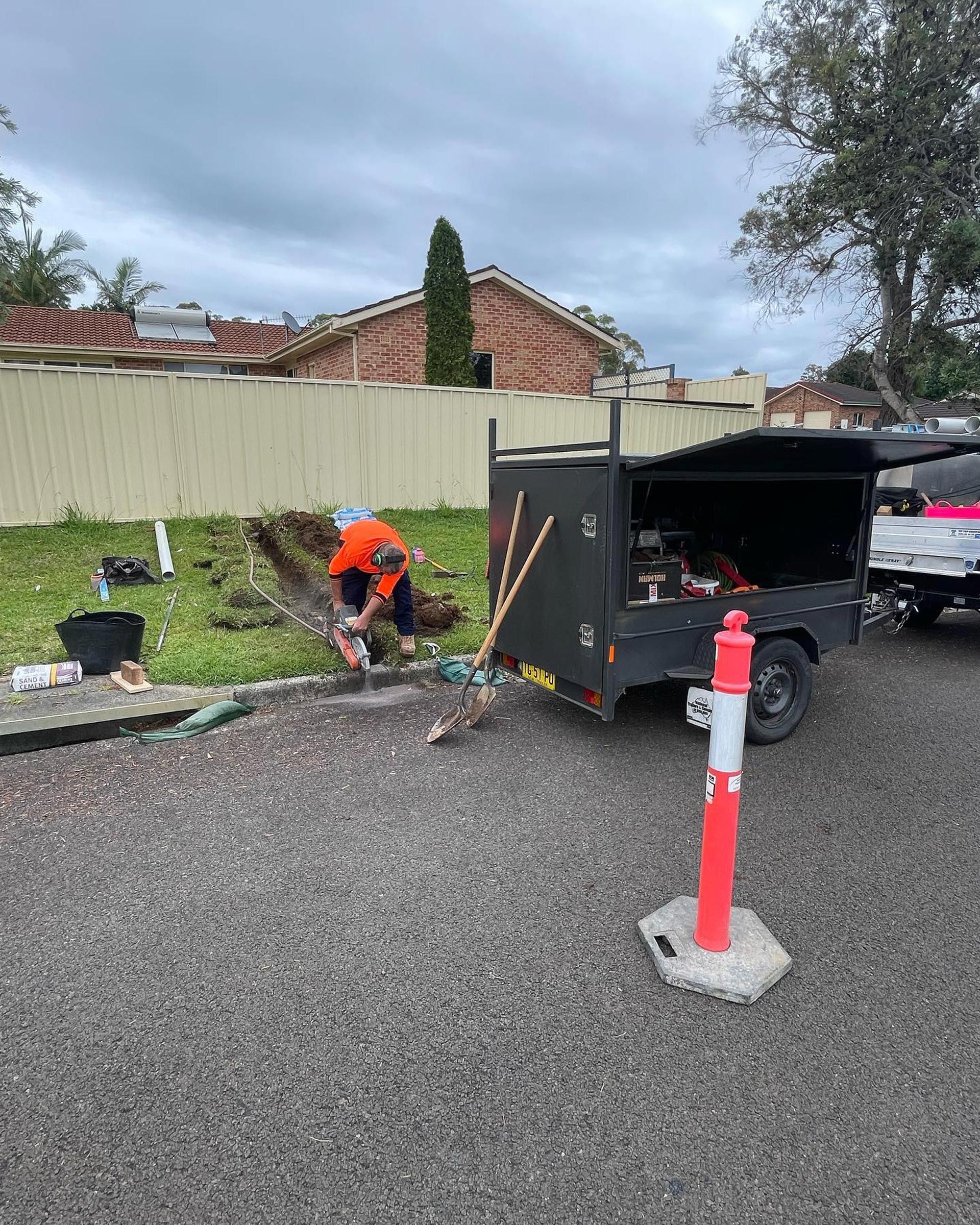 Plumber Working In Front Yard — Bridge Plumbing & Trades in Nowra, NSW