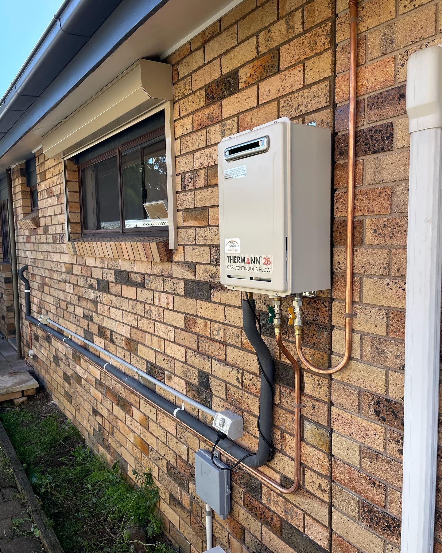 Installed Gas Tank for Hot Water Besides A Wall — Bridge Plumbing & Trades in Nowra, NSW