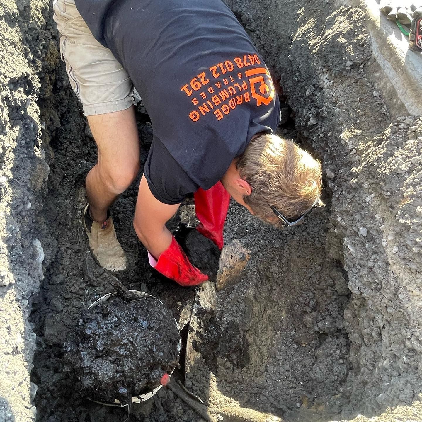 Plumber working on pipes underground