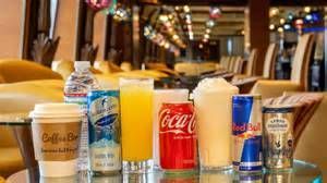 Assorted soda and water bottles lined up on a table in a restaurant setting
