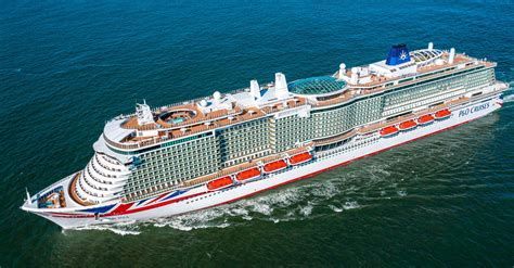 Large white cruise ship sailing on blue ocean, seen from above