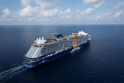 Large cruise ship sailing on calm blue ocean under a partly cloudy sky