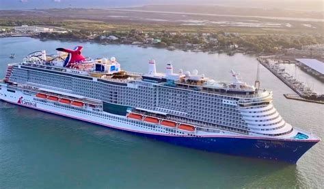 Large cruise ship sailing in calm water near a coastal shoreline at sunset Large cruise ship sailing in calm water near a coastal shoreline at sunset
