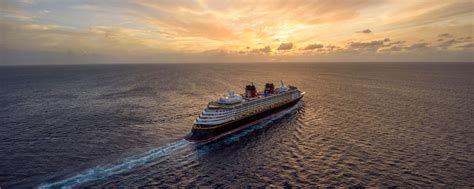 Cruise ship sailing on a calm ocean at sunset with a warm orange sky