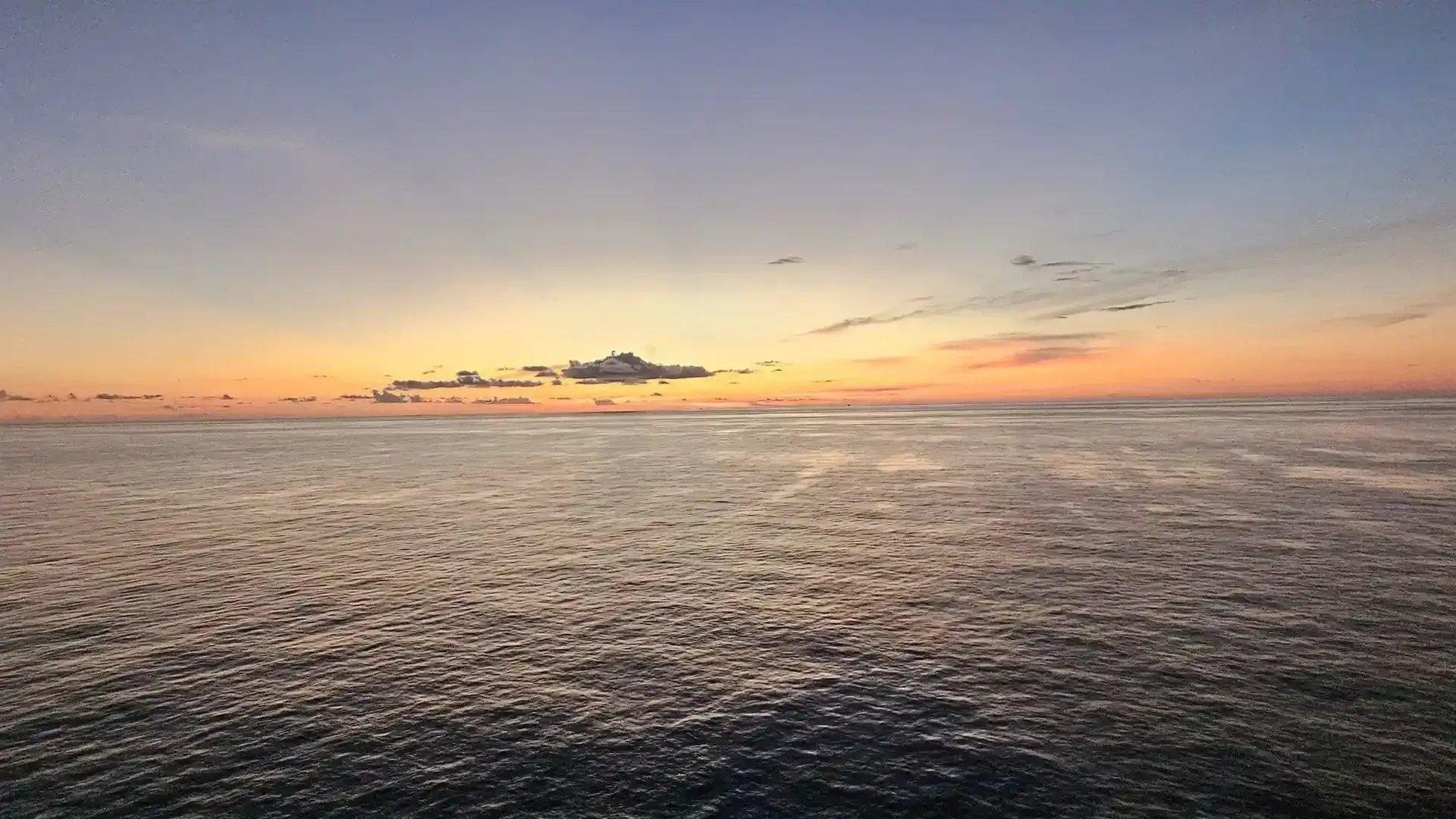 A large body of water with a sunset in the background.