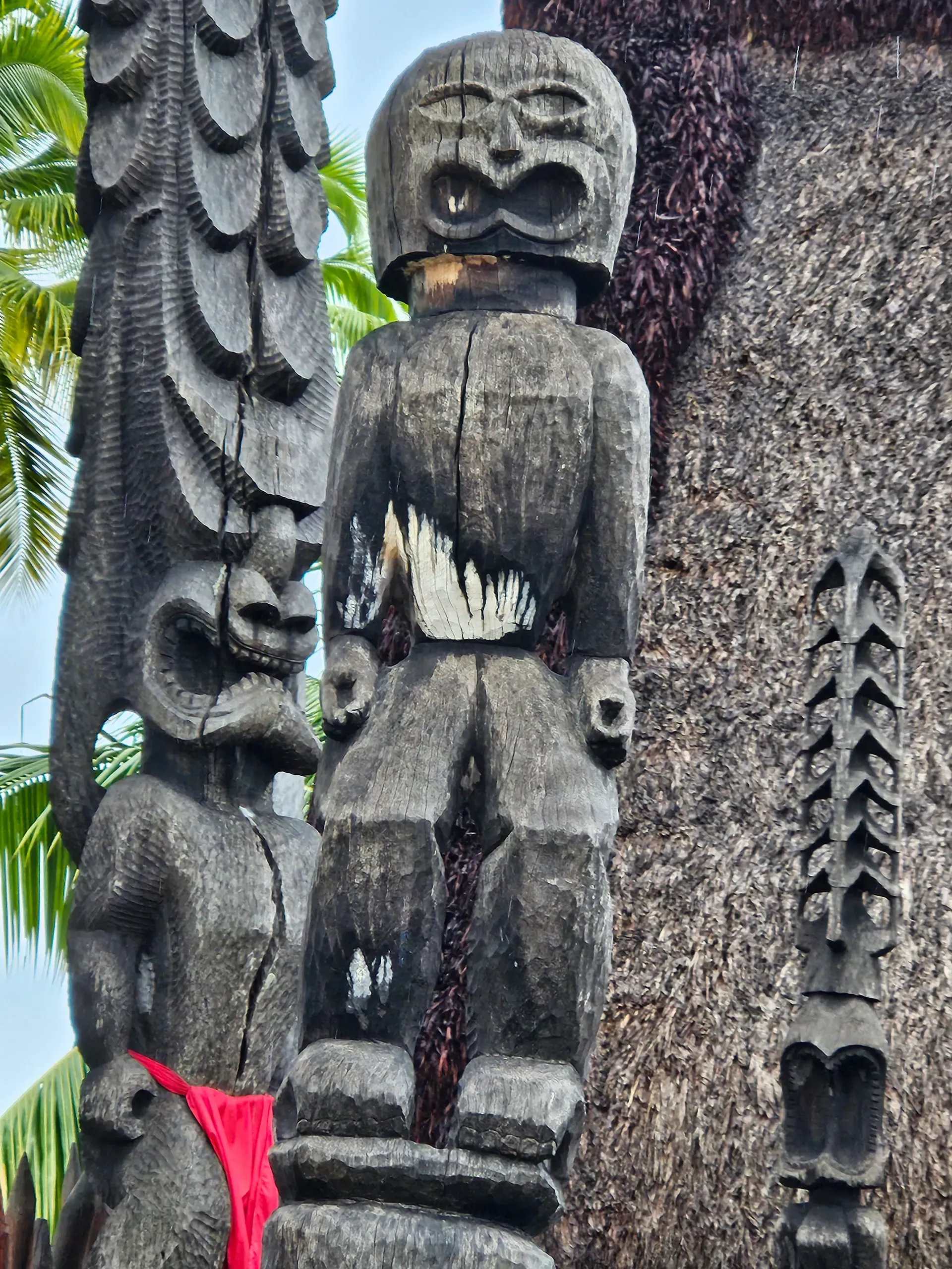 A statue of a man standing next to another statue on a pole.