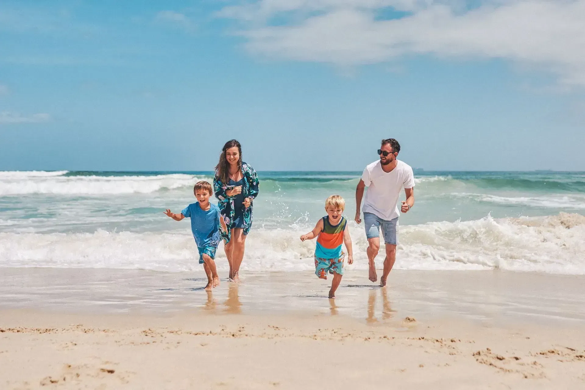 A family is running on the beach.