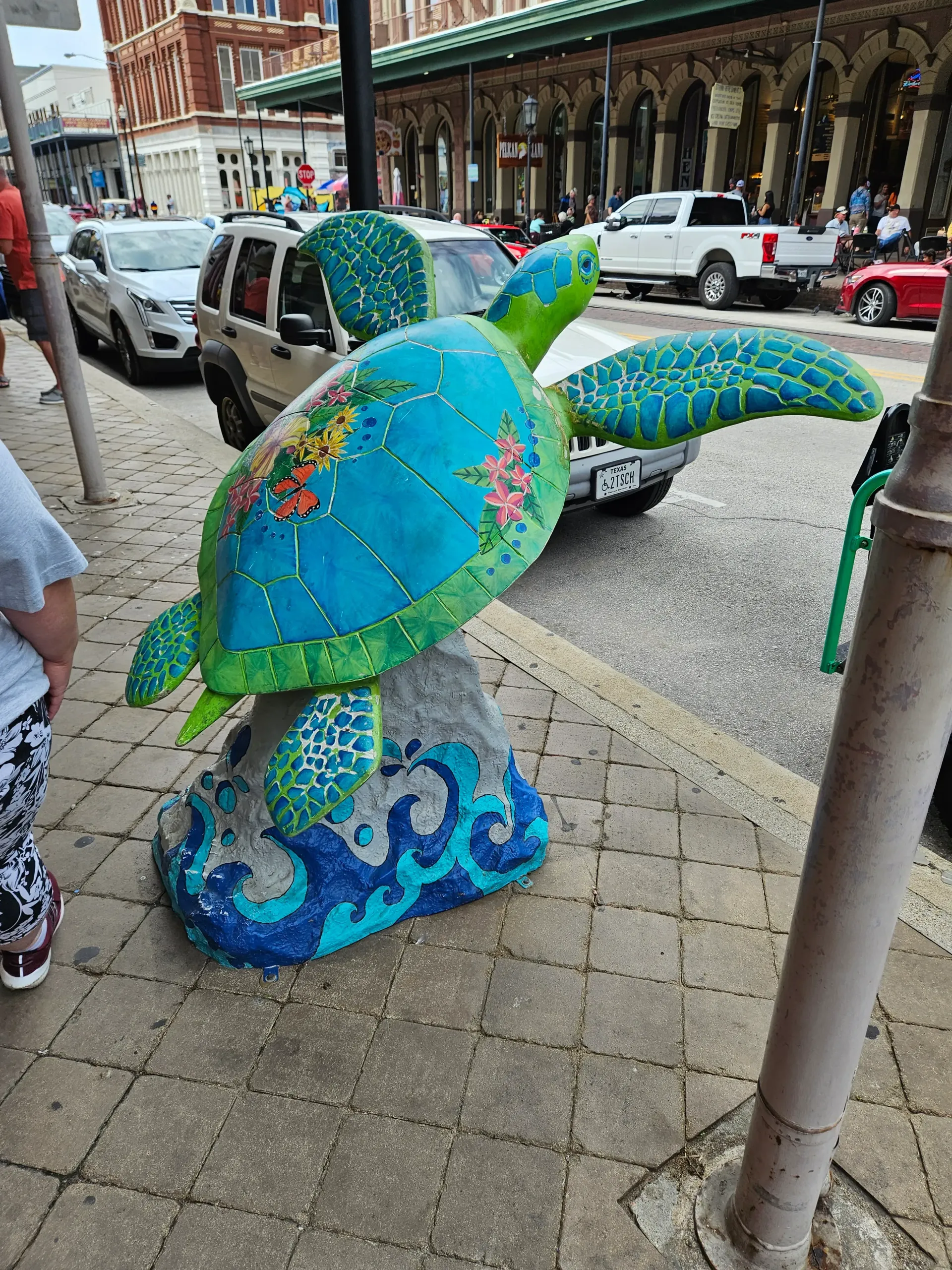A statue of a sea turtle is sitting on the sidewalk.
