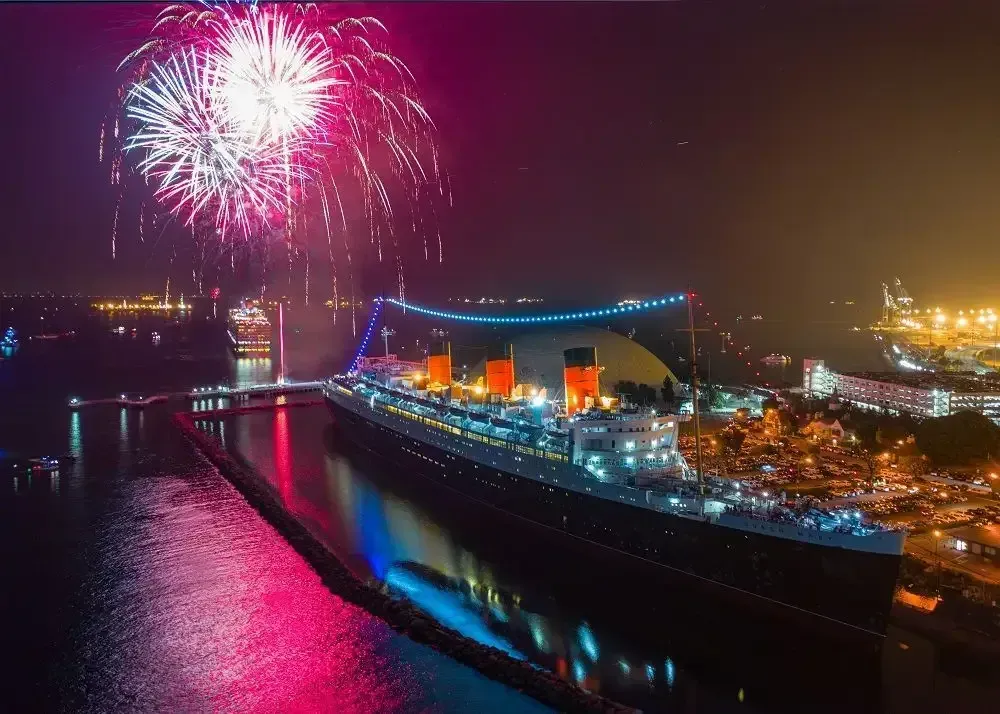 An aerial view of a cruise ship with fireworks in the background
