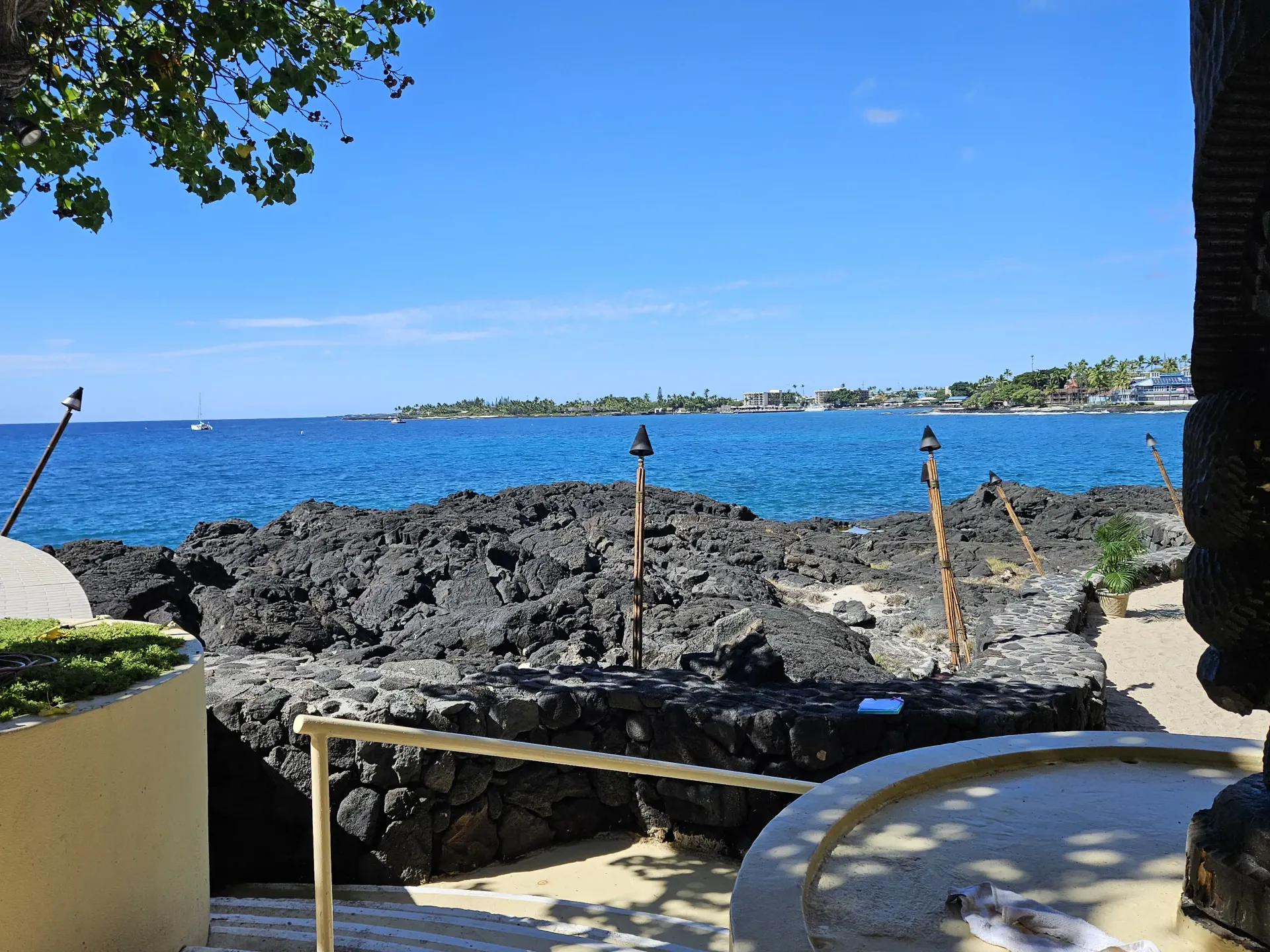 A view of the ocean from a beach with a fountain in the foreground