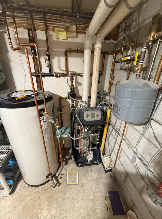 Utility room with water heater, boiler, exposed pipes, and a gray expansion tank.