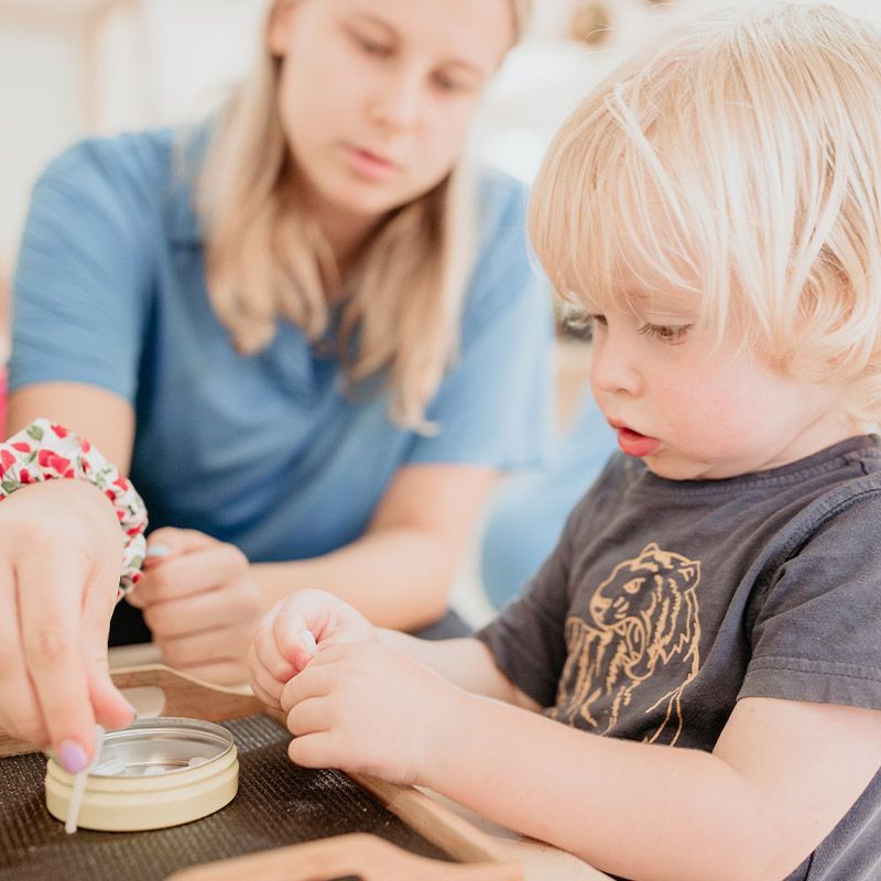 Teacher guiding child through Montessori materials at Spring Hill childcare