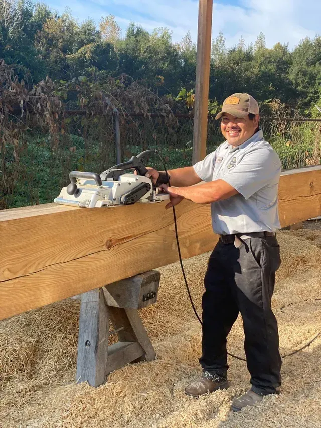 A man is using a chainsaw to cut a piece of wood.